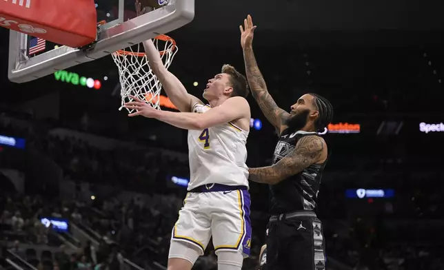 Los Angeles Lakers' Dalton Knecht (4) goes to the basket against San Antonio Spurs' Julian Champagnie during the first half of an Emirates NBA Cup basketball game, Friday, Nov. 15, 2024, in San Antonio. (AP Photo/Darren Abate)