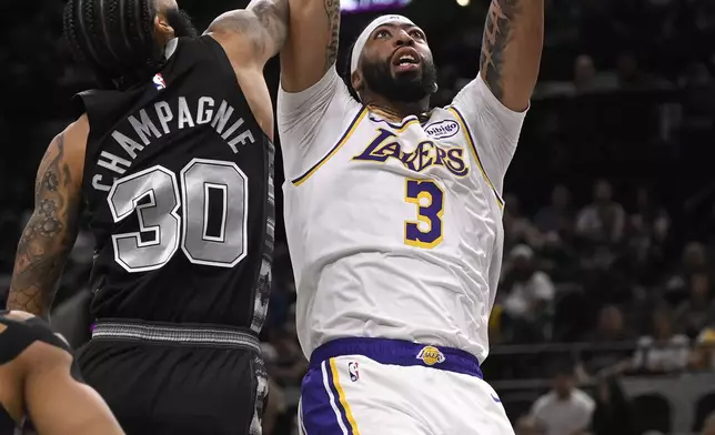 Los Angeles Lakers' Anthony Davis (3) dunks against San Antonio Spurs' Julian Champagnie during the first half of an Emirates NBA Cup basketball game, Friday, Nov. 15, 2024, in San Antonio. (AP Photo/Darren Abate)