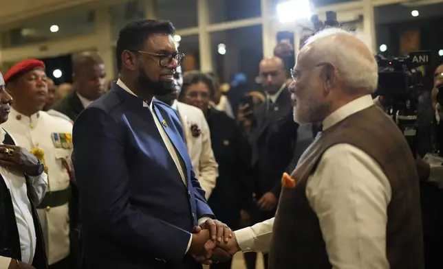 Guyana's President Mohamed Irfaan Ali, left, shakes hands with India's Prime Minister Narendra Modi as he arrives from the airport to his hotel in Georgetown, Guyana, Tuesday, Nov. 19, 2024. (AP Photo/Matias Delacroix)