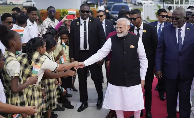 India's Prime Minister Narendra Modi greets students as he arrives to Parliament in Georgetown, Guyana, Thursday, Nov. 21, 2024. (AP Photo/Matias Delacroix)