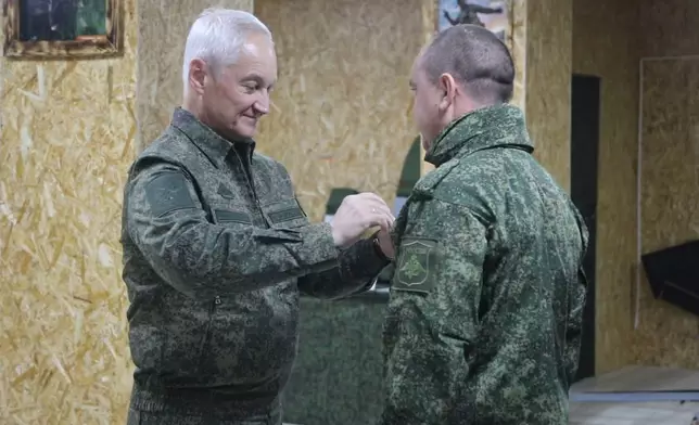 In this photo taken from a video released by Russian Defense Ministry press service on Friday, Nov. 22, 2024, Russian Defense Minister Andrei Belousov, left, gives an award to Russian serviceman of the Battlegroup North in an undisclosed location. (Russian Defense Ministry Press Service via AP)