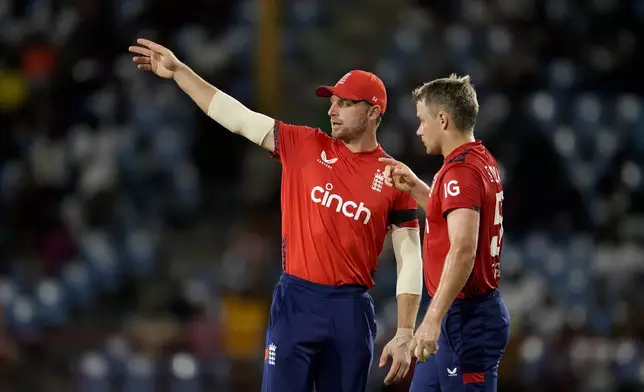 England's captain Jos Buttler, left, talks to Sam Curran during the fourth T20 cricket match against West Indies at Daren Sammy National Cricket Stadium in Gros Islet, St. Lucia, Saturday, Nov. 16, 2024. (AP Photo/Ricardo Mazalan)