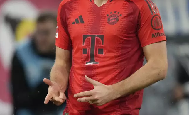 Bayern's Harry Kane celebrates after scoring the opening goal with the penalty kick during the Bundesliga soccer match between Bayern Munich and Augsburg at the Allianz Arena in Munich, Germany, Friday, Nov. 22, 2024. (AP Photo/Matthias Schrader)