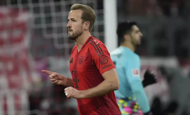 Bayern's Harry Kane celebrates after scoring the opening goal with the penalty kick during the Bundesliga soccer match between Bayern Munich and Augsburg at the Allianz Arena in Munich, Germany, Friday, Nov. 22, 2024. (AP Photo/Matthias Schrader)