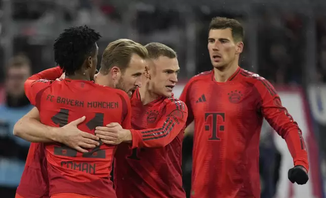 Bayern's Harry Kane, second left, celebrates with teammates after scoring the opening goal with the penalty kick during the Bundesliga soccer match between Bayern Munich and Augsburg at the Allianz Arena in Munich, Germany, Friday, Nov. 22, 2024. (AP Photo/Matthias Schrader)