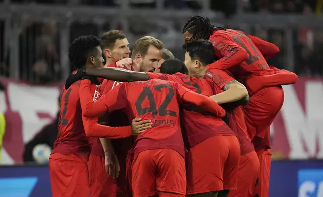 Bayern's Harry Kane, third left, celebrates with teammates after scoring the opening goal with the penalty kick during the Bundesliga soccer match between Bayern Munich and Augsburg at the Allianz Arena in Munich, Germany, Friday, Nov. 22, 2024. (AP Photo/Matthias Schrader)