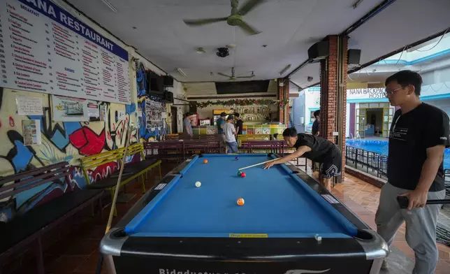 A man plays pool at Nana Backpack hostel in Vang Vieng, Laos, Tuesday, Nov. 19, 2024. (AP Photo/Anupam Nath)