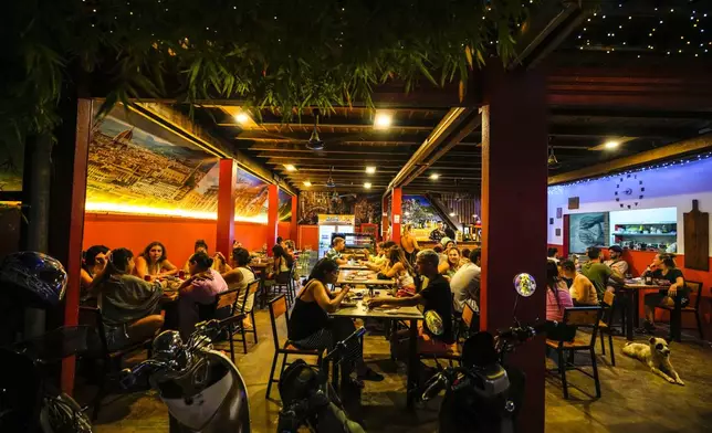 Foreign tourists have a drink at a night club at Nana Backpack hostel in Vang Vieng, Laos, Tuesday, Nov. 19, 2024. (AP Photo/Anupam Nath)