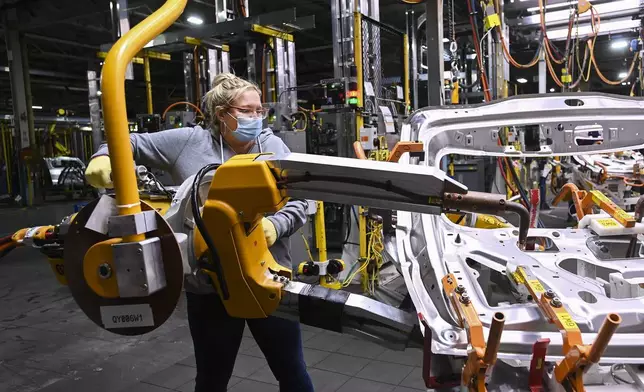 FILE - GM workers use human assistance automation to weld vehicle doors at the General Motors assembly plant during the COVID-19 pandemic in Oshawa, Ontario, March 19, 2021. (Nathan Denette/The Canadian Press via AP, File)