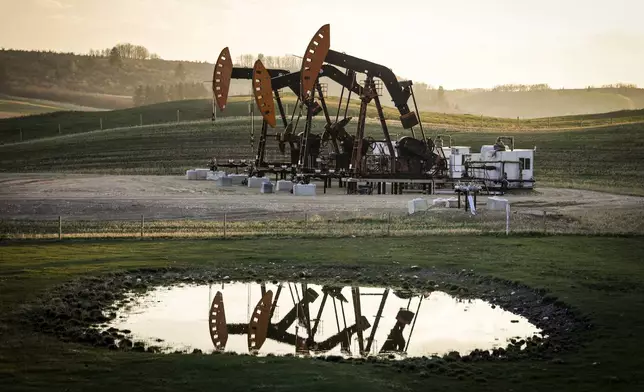 FILE - Pumpjacks draw out oil and gas from well heads as wildfire smoke hangs in the air near Calgary, Alberta, Sunday, May 12, 2024. (Jeff McIntosh/The Canadian Press via AP, File)