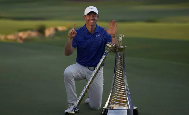 Rory McIlroy of Northern Ireland poses with the DP World Tour Championship trophy and the Race to Dubai trophy after winning the World Tour Golf Championship in Dubai, United Arab Emirates, Sunday, Nov. 17, 2024. (AP Photo/Altaf Qadri)