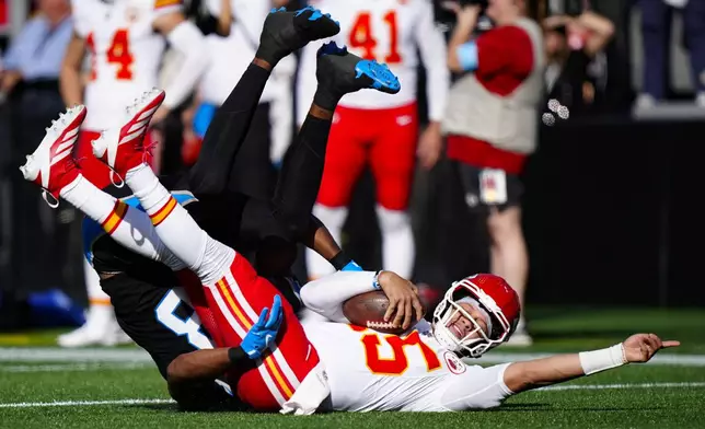 Carolina Panthers linebacker D.J. Wonnum (98) tackles Kansas City Chiefs quarterback Patrick Mahomes (15) during the first half of an NFL football game, Sunday, Nov. 24, 2024, in Charlotte, N.C. (AP Photo/Jacob Kupferman)