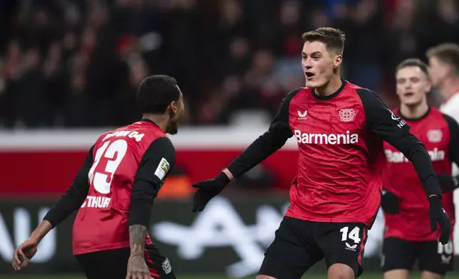 Leverkusen's scorer Patrik Schick, front right, and his teammate Arthur Augusto, left, celebrate their side's fourth goal during the German Bundesliga soccer match between Bayer 04 Leverkusen and 1. FC Heidenheim 1846 in Leverkusen, Germany, Saturday, Nov. 23, 2024. (Marius Becker/dpa via AP)