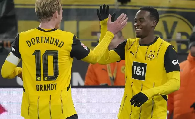 Dortmund's Jamie Bynoe-Gittens, right, celebrates after scoring with his teammate Julian Brandt during the German Bundesliga soccer match between Borussia Dortmund and SC Freiburg at the Signal-Iduna Park in Dortmund, Germany, Saturday, Nov. 23, 2024. (AP Photo/Martin Meissner)