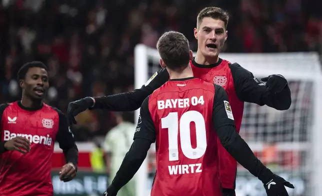 Leverkusen's scorer Patrik Schick, right, and his teammate Florian Wirtz celebrate their side's third goal during the German Bundesliga soccer match between Bayer 04 Leverkusen and 1. FC Heidenheim 1846 in Leverkusen, Germany, Saturday, Nov. 23, 2024. (Marius Becker/dpa via AP)