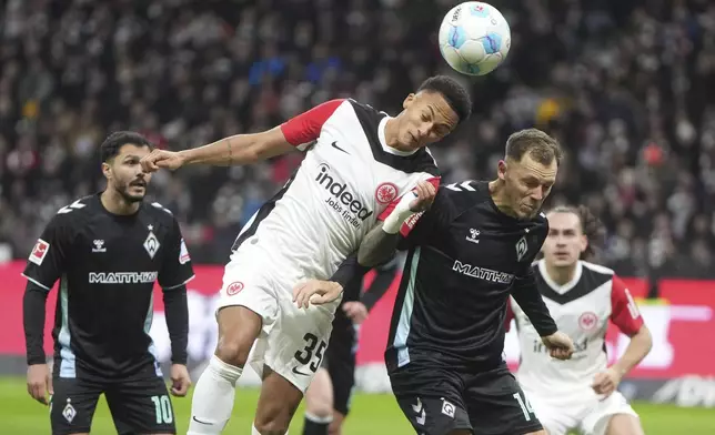 Frankfurt's Tuta, left, and Bremen's Senne Lynen fight for a header during the German Bundesliga soccer match between Eintracht Frankfurt and Werder Bremen in Frankfurt Main, Germany, Saturday, Nov. 23, 2024. (Thomas Frey/dpa via AP)