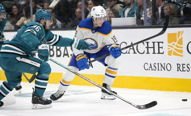 Buffalo Sabres center Peyton Krebs (19) battles for the puck against San Jose Sharks defenseman Jake Walman (96) during the second period of an NHL hockey game in San Jose, Calif., Saturday, Nov. 23, 2024. (AP Photo/Tony Avelar)