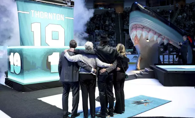 Joe Thornton, second from right, hugs members of his family during a ceremony to retire his jersey before an NHL Hockey game between the San Jose Sharks and the Buffalo Sabres, Saturday, Nov. 23, 2024 in San Jose, California. (Ezra Shaw/ Pool Photo via AP)