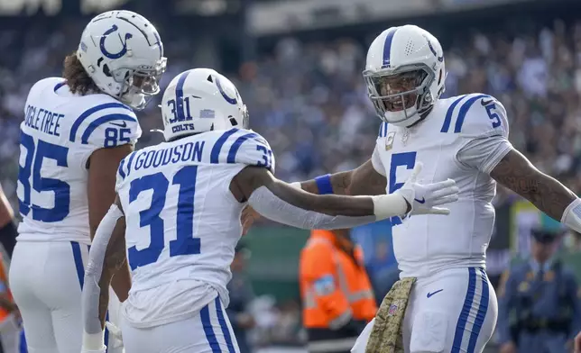 Indianapolis Colts quarterback Anthony Richardson (5) celebrates with running back Tyler Goodson (31) and tight end Drew Ogletree (85) after scoring a touchdown against the New York Jets during the second quarter of an NFL football game, Sunday, Nov. 17, 2024, in East Rutherford, N.J. (AP Photo/Seth Wenig)