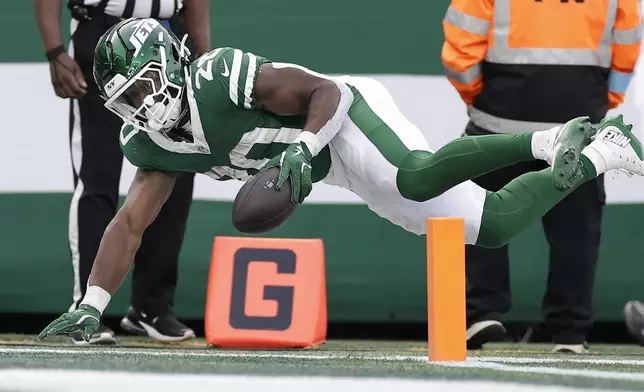 New York Jets running back Breece Hall (20) reaches the ball across the goal line for a touchdown against the Indianapolis Colts during the third quarter of an NFL football game, Sunday, Nov. 17, 2024, in East Rutherford, N.J. (AP Photo/Adam Hunger)