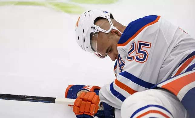 Edmonton Oilers defenseman Darnell Nurse (25) lays on the ice after colliding with Toronto Maple Leafs right wing Ryan Reaves (75) during the second period of an NHL hockey game, Saturday, Nov. 16, 2024 in Toronto. (Christopher Katsarov/The Canadian Press via AP)