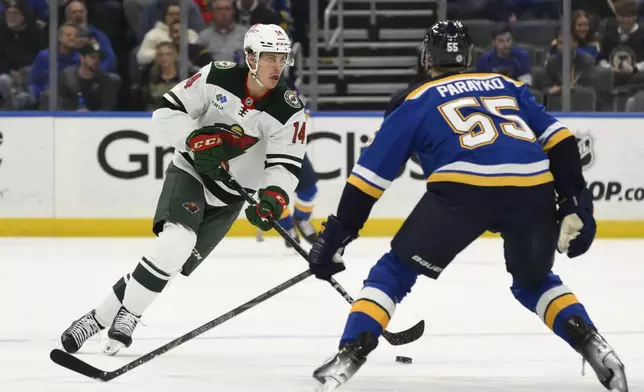 Minnesota Wild center Joel Eriksson Ek (14) controls the puck from St. Louis Blues defenseman Colton Parayko (55) during the first period of an NHL hockey game Tuesday, Nov. 19, 2024, in St. Louis. (AP Photo/Jeff Le)