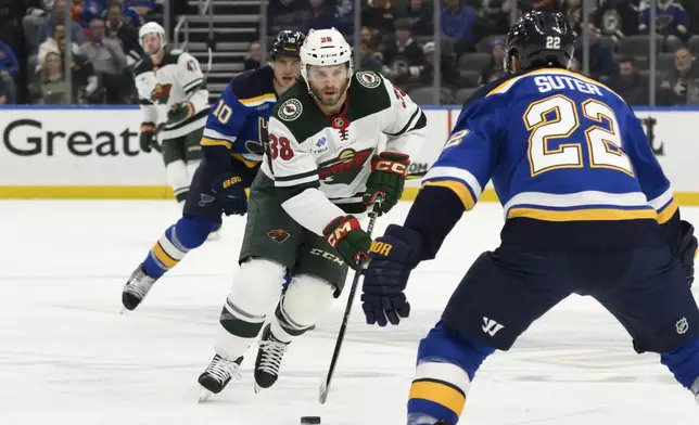 Minnesota Wild right wing Ryan Hartman (38) skates against St. Louis Blues defenseman Ryan Suter (22) during the first period of an NHL hockey game Tuesday, Nov. 19, 2024, in St. Louis. (AP Photo/Jeff Le)