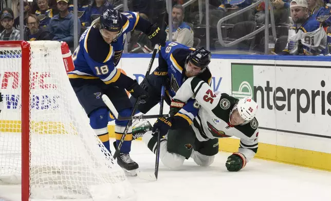 Minnesota Wild defenseman Jonas Brodin (25) is checked by St. Louis Blues left wing Pavel Buchnevich (89) as center Robert Thomas (18) controls the puck during the second period of an NHL hockey game Tuesday, Nov. 19, 2024, in St. Louis. (AP Photo/Jeff Le)