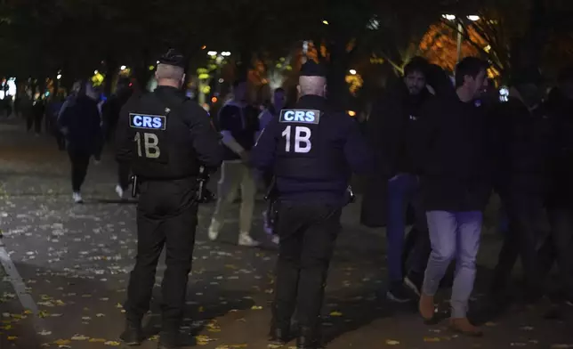 Police officers watch supporters arriving ahead of the Nations League soccer match France against Israel outside the Stade de France stadium, Thursday, Nov. 14, 2024 in Saint-Denis, outside Paris. (AP Photo/Aurelien Morissard)