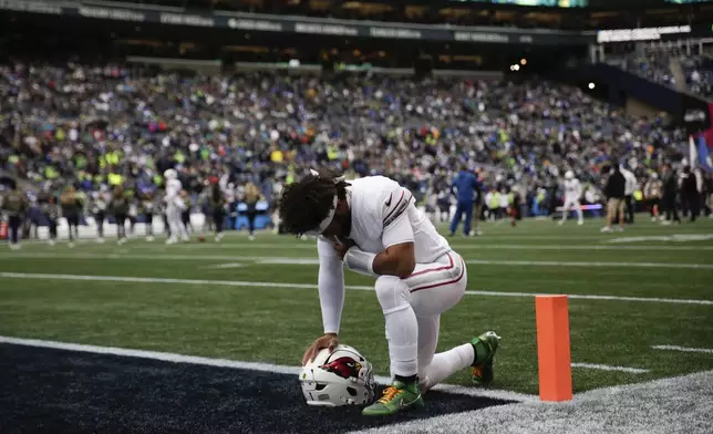 Arizona Cardinals quarterback Kyler Murray (1) pauses before joining teammates before an NFL football game against the Seattle Seahawks, Sunday, Nov. 24, 2024, in Seattle. (AP Photo/Jason Redmond)