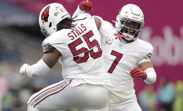 Arizona Cardinals defensive tackle Dante Stills (55) and linebacker Kyzir White (7) celebrate during the first half of an NFL football game against the Seattle Seahawks, Sunday, Nov. 24, 2024, in Seattle. (AP Photo/Jason Redmond)