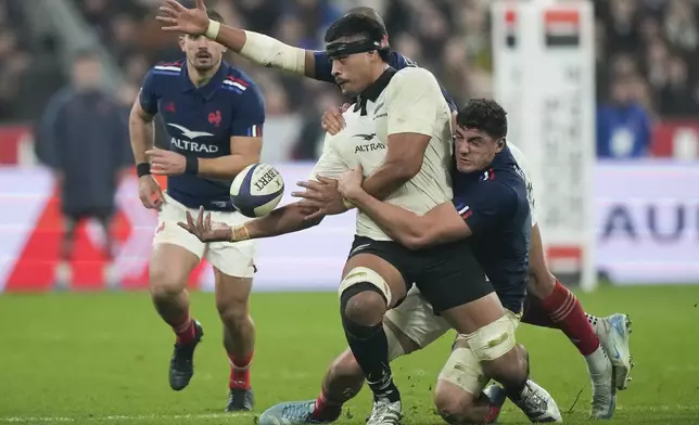 New Zealand's Tupou Vaa'i passes the ball as he is tackled during the Autumn Nations series rugby union match between France and All Blacks at the Stade de France stadium, in Saint-Denis, outside Paris, Saturday, Nov. 16, 2024. (AP Photo/Michel Euler)