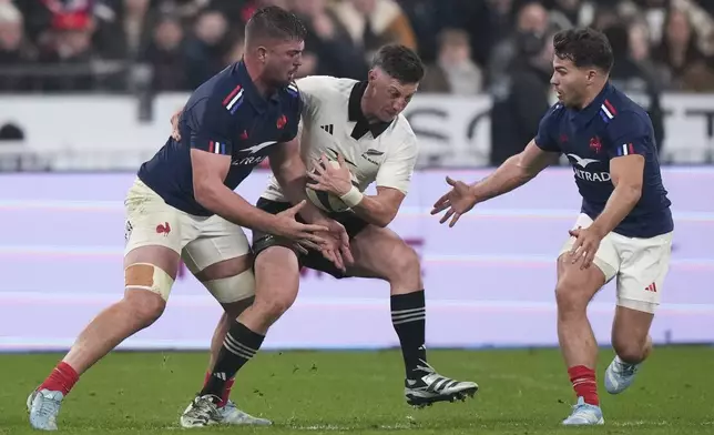 New Zealand's Cam Roigard, takes the ball from France's Antoine Dupont, right, and Grégory Alldritt, left, to score his team's second try during the Autumn Nations series rugby union match between France and New Zealand at the Stade de France stadium, in Saint-Denis, outside Paris, Saturday, Nov. 16, 2024. (AP Photo/Michel Euler)