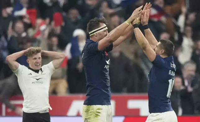 France's Thomas Ramos, right, celebrates with teammate Alexandre Roumat after winning the Autumn Nations series rugby union match against the All Blacks at the Stade de France stadium, in Saint-Denis, outside Paris, Saturday, Nov. 16, 2024. (AP Photo/Michel Euler)