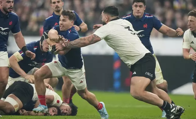 France's Antoine Dupont runs past New Zealand's Tyrel Lomax during the Autumn Nations series rugby union match between France and New Zealand at the Stade de France stadium, in Saint-Denis, outside Paris, Saturday, Nov. 16, 2024. (AP Photo/Michel Euler)