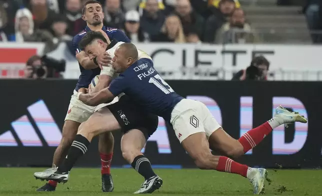 New Zealand's Cam Roigard is tackled by France's Gaël Fickou, right, and Romain Buros during the Autumn Nations series rugby union match between France and New Zealand at the Stade de France stadium, in Saint-Denis, outside Paris, Saturday, Nov. 16, 2024. (AP Photo/Michel Euler)