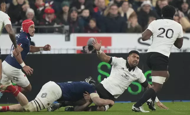 New Zealand's Ardie Savea passes the ball to teammate Peter Lakai, right, to score their first try during the Autumn Nations series rugby union match between France and New Zealand at the Stade de France stadium, in Saint-Denis, outside Paris, Saturday, Nov. 16, 2024. (AP Photo/Michel Euler)