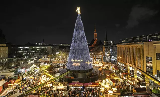 The traditional 45 meter high Dortmund Christmas tree, one of the world's largest, is illuminated for the first time this year at the Christmas market in Dortmund, Germany, Monday, Nov. 25, 2024. (AP Photo/Martin Meissner)