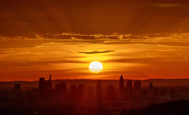 The sun rises behind buildings of the banking district in Frankfurt, Germany, Monday, Nov. 25, 2024. (AP Photo/Michael Probst)