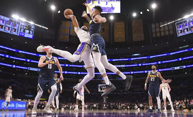 Los Angeles Lakers forward Anthony Davis, second from left, shoots as Denver Nuggets forward Michael Porter Jr. defends during the first half of an NBA basketball game, Saturday, Nov. 23, 2024, in Los Angeles. (AP Photo/Mark J. Terrill)