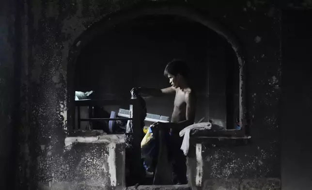 A resident salvages belongings from his burned home the day after a fire broke out, leaving thousands of families homeless, in a poor area of Manila, Philippines, Monday, Nov. 25, 2024. (AP Photo/Aaron Favila)