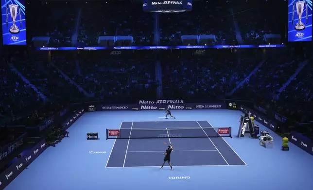 United States' Taylor Fritz, bottom, returns the ball to Australia's Alex de Minaur during their singles tennis match of the ATP World Tour Finals at the Inalpi Arena, in Turin, Italy, Thursday, Nov. 14, 2024. (AP Photo/Antonio Calanni)