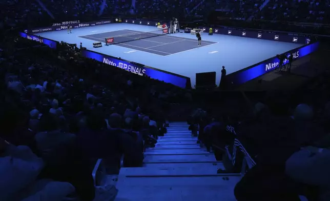 United States' Taylor Fritz, right, serves the ball to Australia's Alex de Minaur during their singles tennis match of the ATP World Tour Finals at the Inalpi Arena, in Turin, Italy, Thursday, Nov. 14, 2024. (AP Photo/Antonio Calanni)