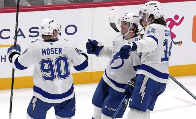 Tampa Bay Lightning's Brayden Point, center, celebrates with J.J. Moser (90) and Conor Geekie (14) after getting the game-winning overtime goal during an NHL hockey game against the Pittsburgh Penguins, Tuesday, Nov. 19, 2024, in Pittsburgh. The Lightning won 3-2. (AP Photo/Gene J. Puskar)