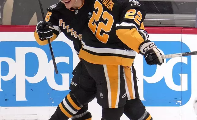 Pittsburgh Penguins' Jesse Puljujarvi, left, celebrates his goal with Sam Poulin (22) during the first period of an NHL hockey game against the Tampa Bay Lightning, Tuesday, Nov. 19, 2024, in Pittsburgh. (AP Photo/Gene J. Puskar)