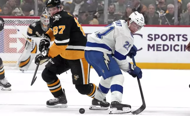 Pittsburgh Penguins' Sidney Crosby (87) and Tampa Bay Lightning's Brayden Point (21) face-off during the second period of an NHL hockey game Tuesday, Nov. 19, 2024, in Pittsburgh. (AP Photo/Gene J. Puskar)