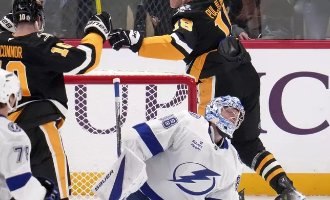 Pittsburgh Penguins' Jesse Puljujarvi, right rear, celebrates his goal against Tampa Bay Lightning goaltender Andrei Vasilevskiy (88) during the first period of an NHL hockey game Tuesday, Nov. 19, 2024, in Pittsburgh. (AP Photo/Gene J. Puskar)