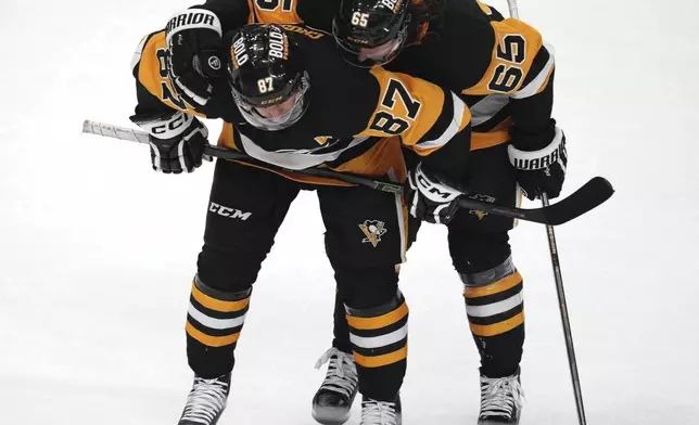 Pittsburgh Penguins' Erik Karlsson (65) and Sidney Crosby (87) prepare for a face off in the overtime period of an NHL hockey game against the San Jose Sharks, Saturday, Nov. 16, 2024, in Pittsburgh. (AP Photo/Gene J. Puskar)