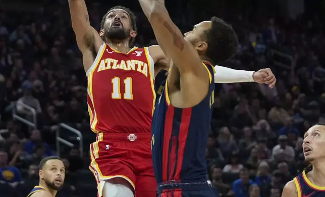 Atlanta Hawks guard Trae Young (11) shoots while defended by Golden State Warriors forward Kyle Anderson, right, during the first half of an NBA basketball game Wednesday, Nov. 20, 2024, in San Francisco. (AP Photo/Godofredo A. Vásquez)