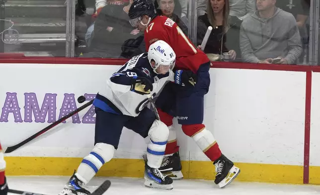 Winnipeg Jets center Cole Perfetti (91) and Florida Panthers center Evan Rodrigues (17) go for the puck during the second period of an NHL hockey game, Saturday, Nov. 16, 2024, in Sunrise, Fla. (AP Photo/Lynne Sladky)